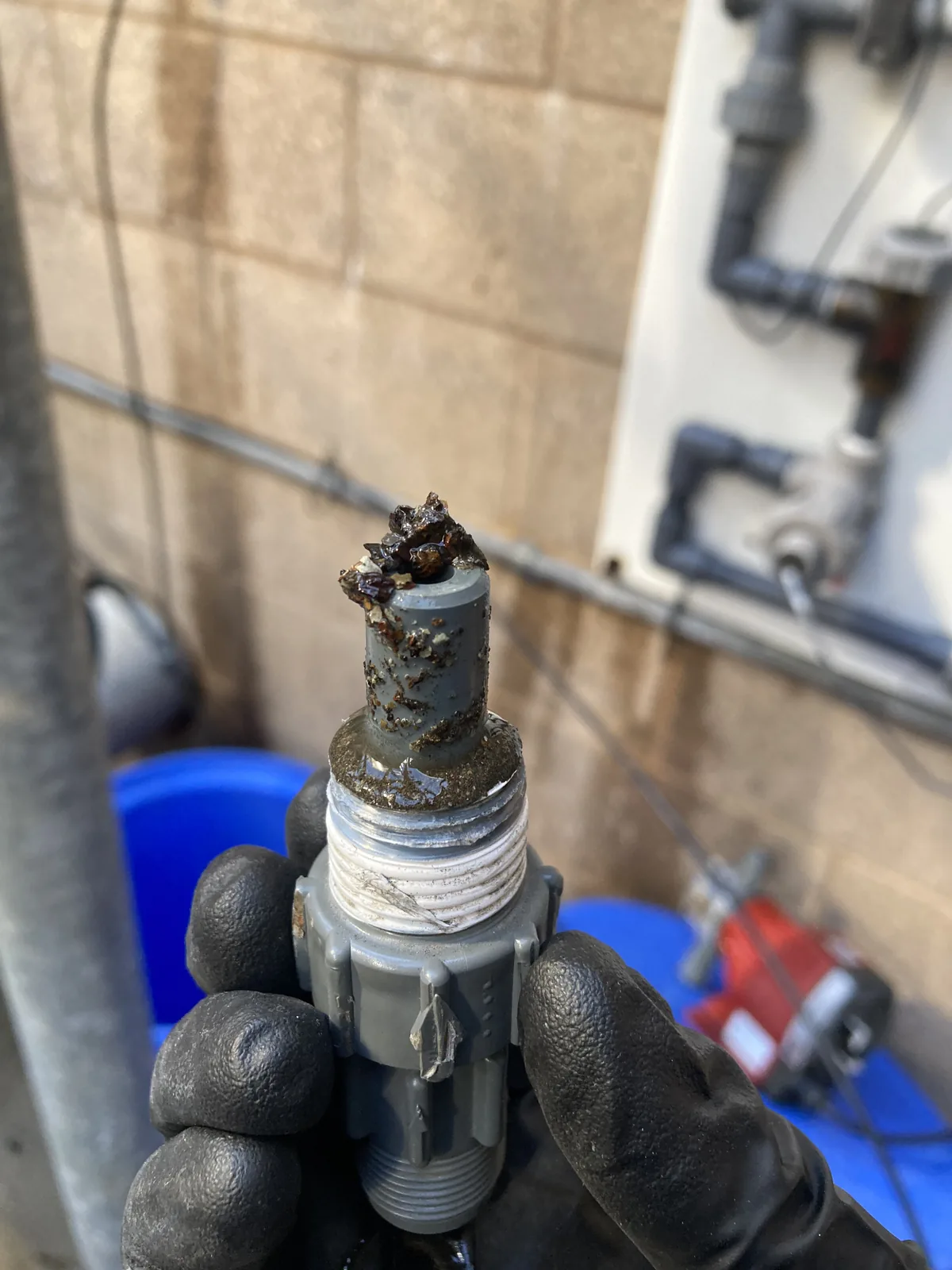 Chemical injection quill with its tip clogged by crusty brown-black buildup